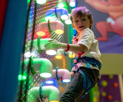 Junge am Klettern an einer Wand im FunPlanet Kids Rennaz