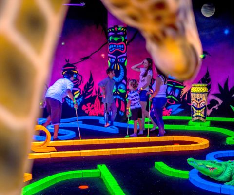 Familie spielt Minigolf im FunPlanet Kids Rennaz