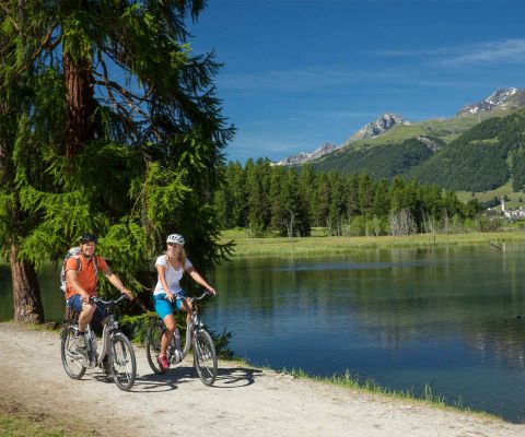 Uomo e donna in bici sul lago di Gravatscha