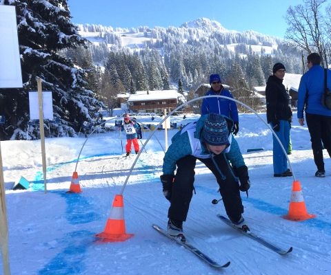 Enfant s’exerçant à passer sous les arceaux sur une piste de ski de fond 