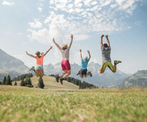 Famiglia fa un salto in aria nel paesaggio montano di Gstaad-Wispile