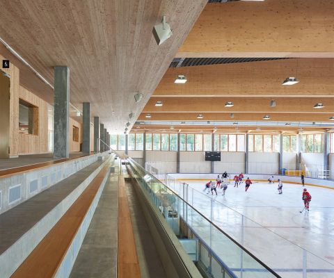 Kinder spielen Eishockey in Eishalle vor leeren Tribünen