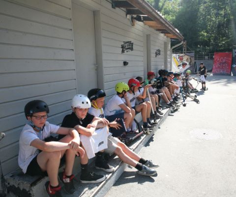 Kinder sitzen vor dem Skate-Park in Lausanne