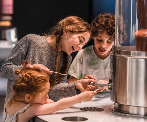 Drei Kinder testen die Lindt Schokolade an einem Schoggibrunnen