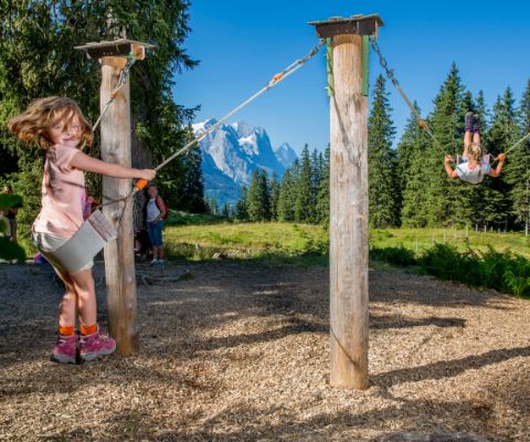 Bambini che giocano nel parco giochi con vista panoramica sulle montagne