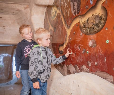 Deux enfants explorant la tanière des marmottes à la Lenk