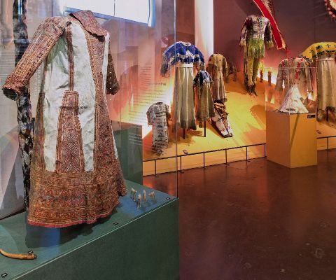 Ausstellungsraum mit Kleider und Kopfschmuck von Indianern