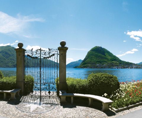 Magnifique porte en fer forgé avec le lac de Lugano en arrière-plan