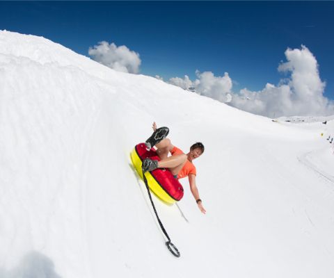 Une femme dévale une piste en snow tubing