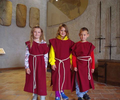 Drei Kinder stehen verkleidet in einem Saal