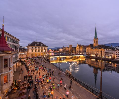 Teilnehmende des Silvesterlaufes rennen entlang der Limmat in Zürich