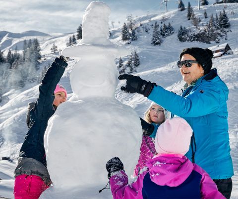 Familie baut einen Schneemann