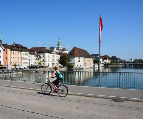 Une cycliste traversant un pont