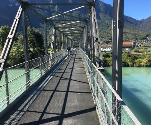 Velofahrer fährt über eine Rhone-Brücke