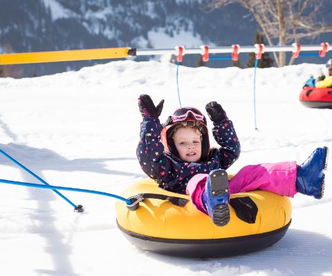 Bambina si diverte nello snowtube a Villars
