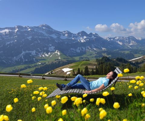 Una signora si rilassa su una sdraio sul Kronberg di fronte a un magnifico panorama