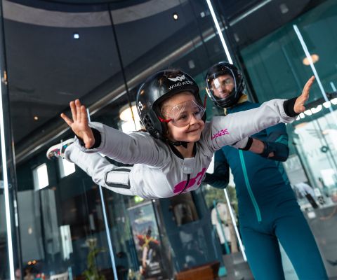 Ein Mädchen schwebt lächelnd in der Flugkammer im Windwerk Winterthur