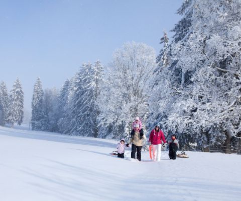 Familie beim Winterwandern in Le Creux-des-Biches 