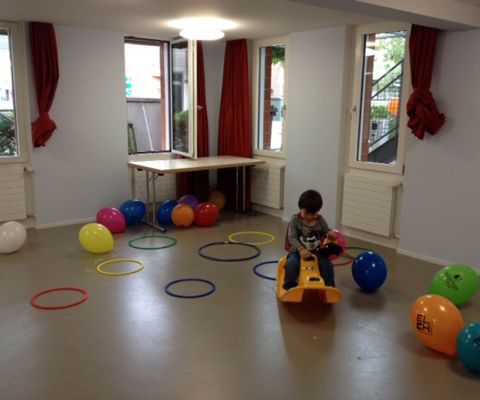 Kleinkind spielt im Kinderspielzimmer gefüllt mit Ballone und Ringe