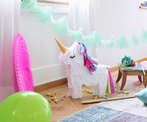 Pentolaccia a forma di unicorno in soggiorno con ghirlanda decorativa