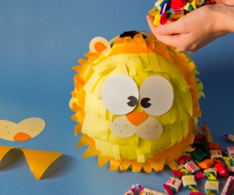 Ein Piñata-Löwe wird mit Süssigkeiten gefüllt.
