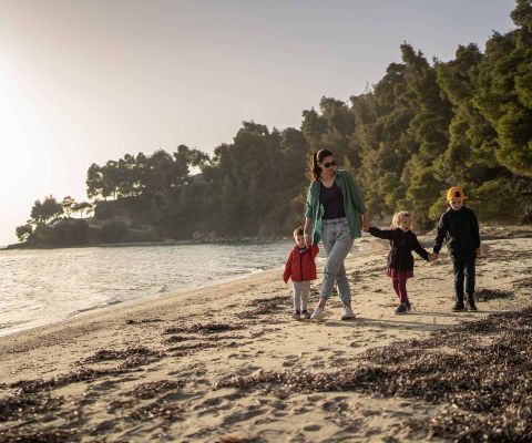Familie läuft den Strand entlang