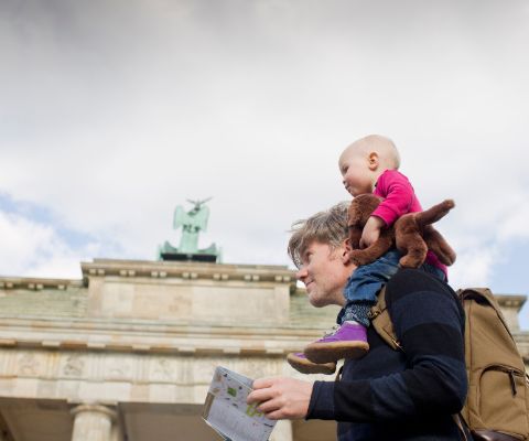 Vater mit Kleinkind auf den Schultern vor Brandenburger Tor