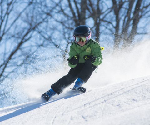 Un enfant dévale une pente à ski