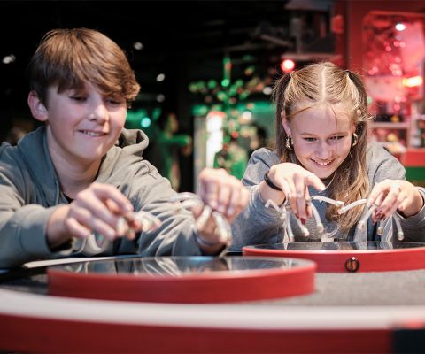 Mädchen und Junge spielen mit Magneten