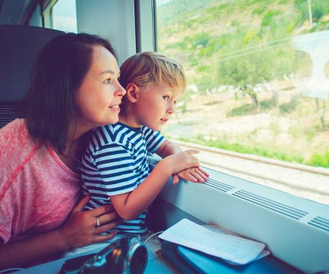 Eine Mutter und ihr Sohn fahren Zug und schauen aus dem Fenster