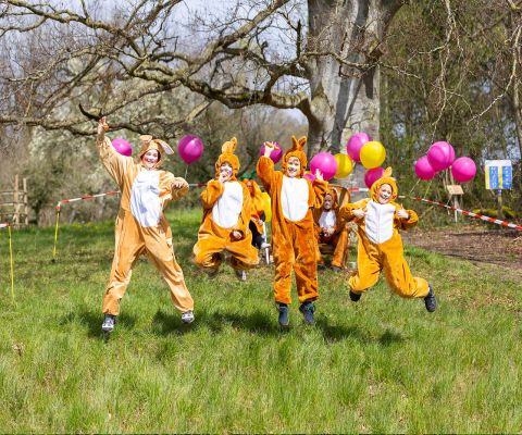 Vier Kinder in Osterhasen-Kostümen haben Spass bei der Ostereierjagd in Murten