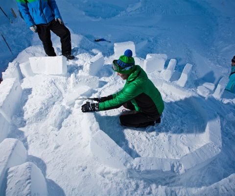 Persone costruiscono un igloo con blocchi di ghiaccio