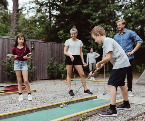 Familie spielt Minigolf