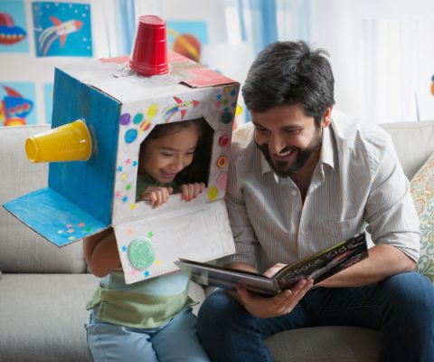 Vater und Tochter am Lesen und Spielen