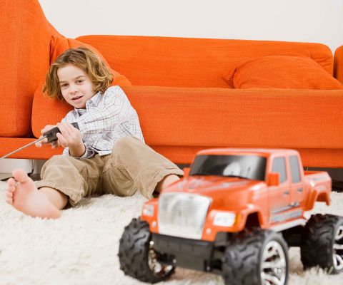 Jouets d’action: petit enfant et sa voiture télécommandée