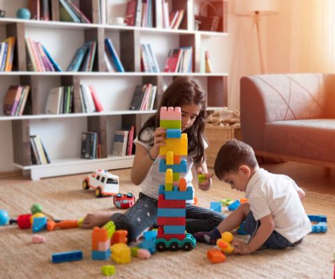 Deux enfants jouent avec des cubes de construction, plongés dans leur propre univers de créativité