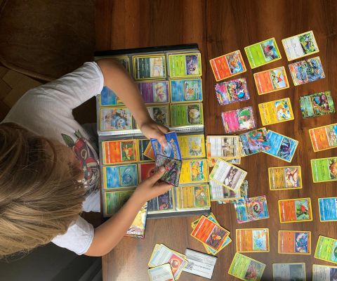 Un garçon collectionne des cartes Pokémon