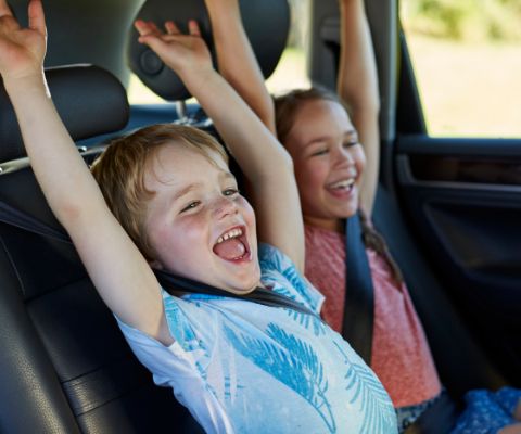 Bambini esultano sul sedile posteriore di un’auto