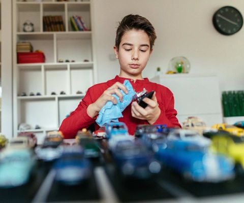 Junge reinigt seine Spielzeug-Autos