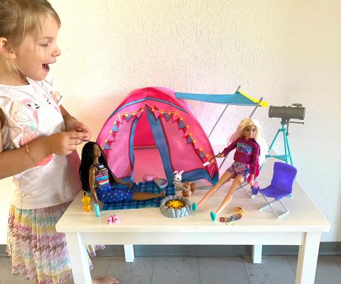 Mädchen freut sich über Barbies Camping Zelt Set