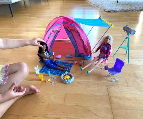 Petite fille jouant avec le set de tente de camping Barbie