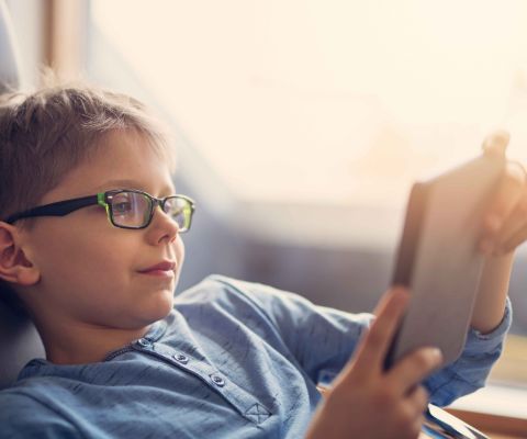 Junge liest E-Book auf seinem E-Reader