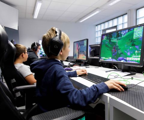 Des enfants et des ados en train de jouer à des jeux vidéo à la Noetic Academy à Fribourg