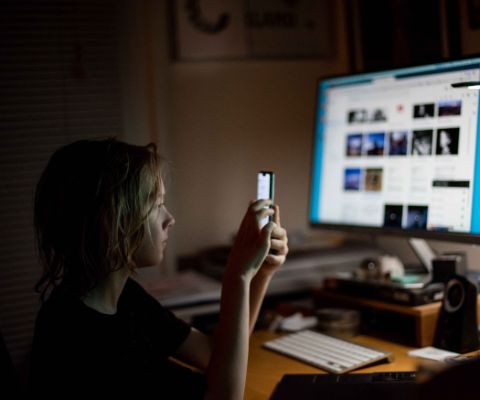 Onlinezeit bei Jugendlichen: Junge mit Smartphone und Computer