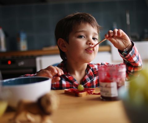 Ernährungskompass bei Kindern: Kleiner Junge isst genüsslich Süsses