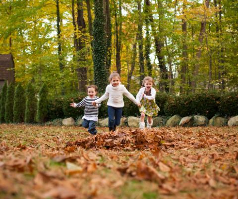 Spielende Kinder in Herbstkleidern