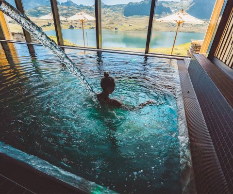 Frau im Pool mit Blick auf Bergsee