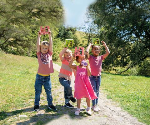 Vier Kinder im Freien halten BEAR Frucht Rollen in die Höhe
