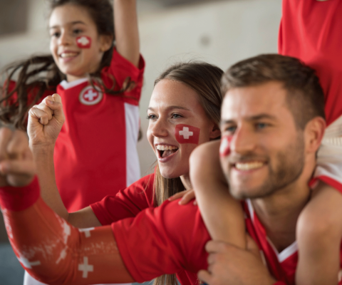 Famille fan de football vêtue de maillots aux couleurs de la Suisse