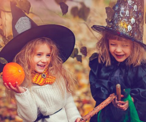 Zwei kleine Mädchen sind zu Halloween als Hexen verkleidet